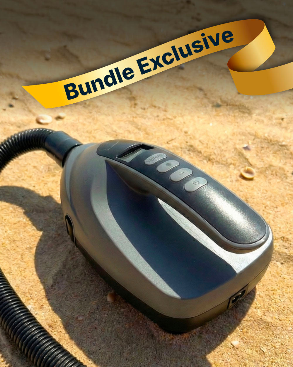 Portable electric pump with buttons, black and gray, on sandy surface with a hose attached