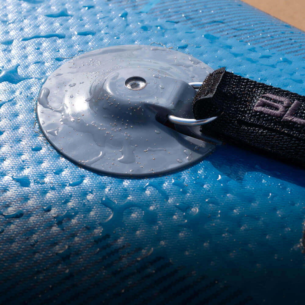 Close-up of a blue inflatable paddleboard's valve with water droplets and a black strap