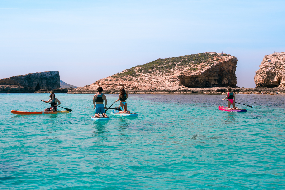 Four people on paddleboards on a bright summers day