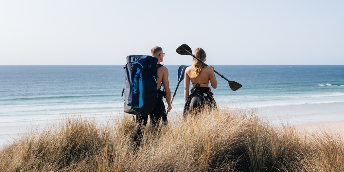 two people getting ready to start paddleboarding