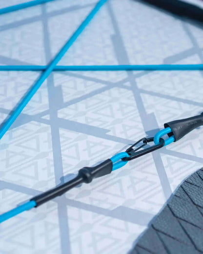 Close-up of a paddleboard's blue bungee cord system and textured deck pad with geometric patterns