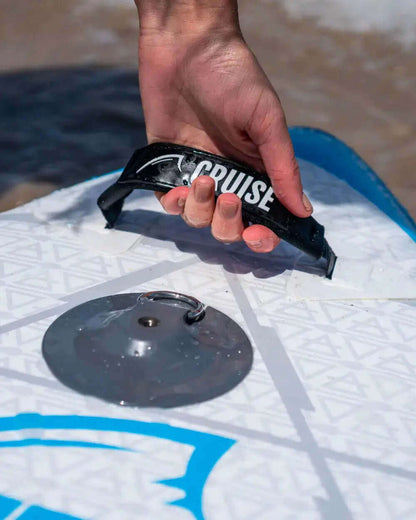 Hand gripping a black handle labeled 'CRUISE' on a paddleboard with a metal valve